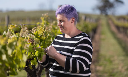 lady looking at grapevines at winery