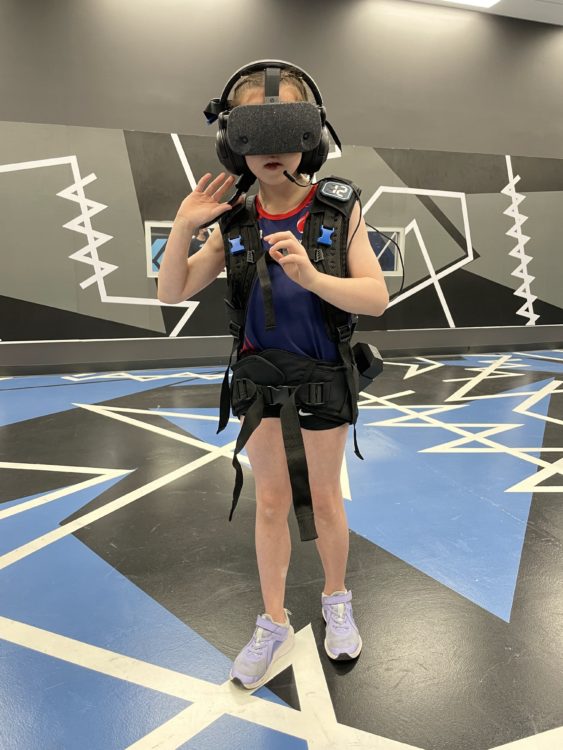 !0 year old girl in VR gear walking in the room