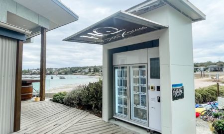 Th oyster vending machine, situated in front of Coffin Bay's Oyster HQ, with the water and oyster lease in the background.