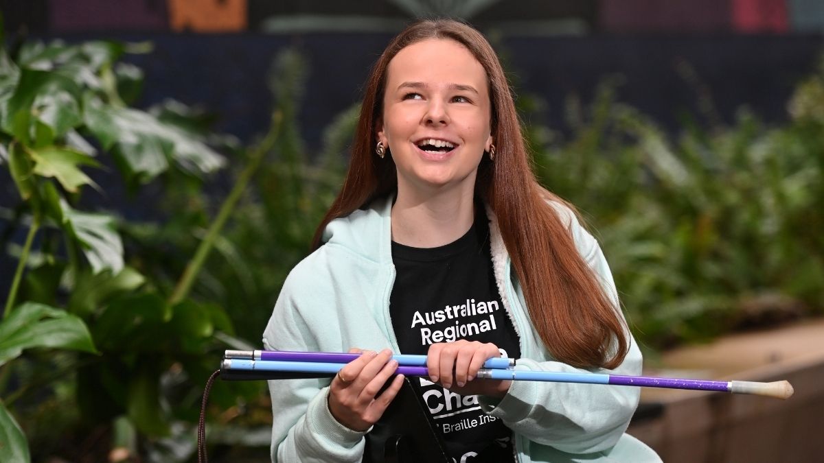 South Australian student Shianne Durdin smiles while holding a purple and blue cane ahead of becoming Australia’s first International Braille Challenge finalist.