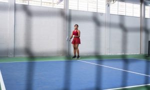 Young woman playing pickleball, holding paddle and getting ready to serve