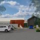 Render of the new eating disorder centre, a low building with timber and dark cladding and a gabled glass front, with cars parked out the front