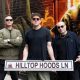 The three members of Hilltop Hoods holding a Hilltop Hoods Ln street sign in the painted laneway