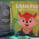 The picture book Little Fox’s Hidden Disability standing beside a glass SLVR award and a green sunflower lanyard