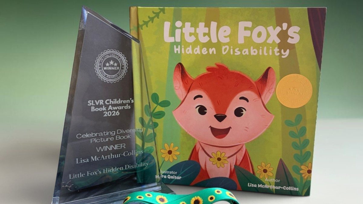 The picture book Little Fox’s Hidden Disability standing beside a glass SLVR award and a green sunflower lanyard