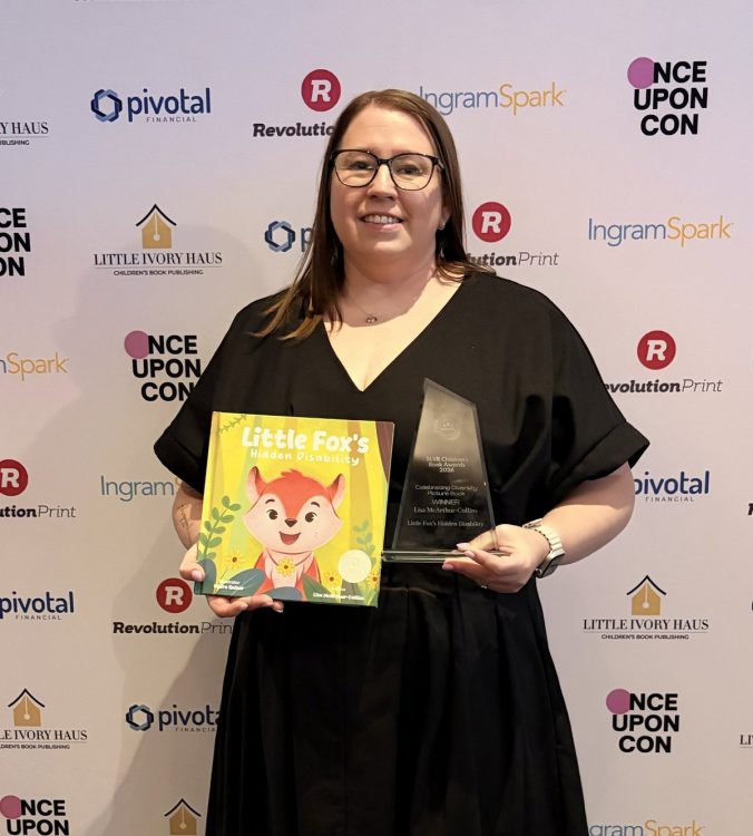 Lisa McArthur-Collins holding her picture book Little Fox’s Hidden Disability and her glass SLVR Children’s Book Awards trophy